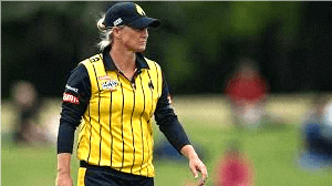 A dynamic image of Sophie Devine, the New Zealand cricketer, hitting a powerful shot on the field with a cheering crowd in the background.